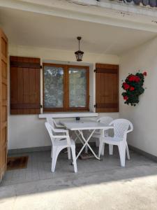 a white table and chairs on a patio at Les Granges 2 chambres et terrasse au soleil in La Clusaz