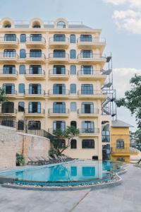 - un grand bâtiment avec une piscine en face dans l'établissement Goldient Boutique Hotel, à Đà Lạt