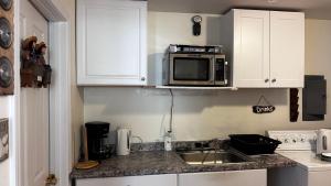 a kitchen with a sink and a microwave at Beach Boutique Apartment in Old Orchard Beach