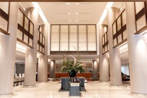 een lobby met pilaren en een vaas met een plant bij Narada Grand Hotel Zhejiang in Hangzhou