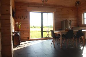uma sala de jantar com uma mesa e cadeiras e uma janela em Dundaga Axe & Archery guesthouse em Dundaga
