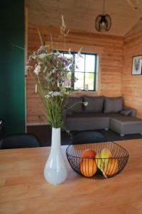 a vase with flowers and fruit on a table at Dundaga Axe & Archery guesthouse in Dundaga