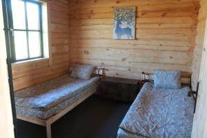 um quarto com duas camas num chalé de madeira em Dundaga Axe & Archery guesthouse em Dundaga
