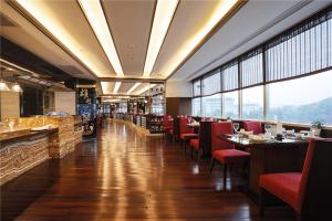 een restaurant met rode stoelen en tafels en ramen bij Narada Grand Hotel Zhejiang in Hangzhou