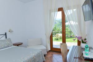 een slaapkamer met een bed en een glazen schuifdeur bij Villevieille in Piano di Sorrento