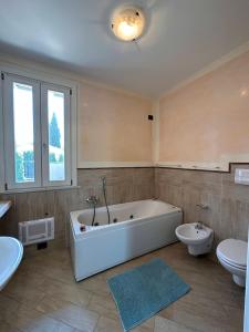 La grande salle de bains est pourvue d'une baignoire et de toilettes. dans l'établissement Villa Oliva, à Manerba del Garda