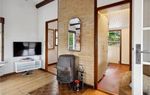 uma sala de estar com uma parede de tijolos e uma televisão em Lovely Home In Solrd Strand With Wifi em Karlstrup Strand