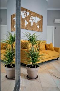 a living room with two potted plants in front of a couch at Margaritas 21 Rooms in Tarifa