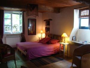 Saint-Martial的住宿－Mas des Nabières，一间卧室配有一张带紫色床单的床和两盏灯。