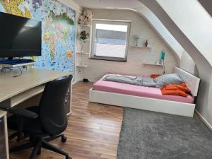 a bedroom with a bed and a desk with a computer at Zimmer HomeOffice Küche WLAN TV mit Terrasse&Grill +Fahrrad in Hove
