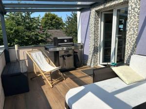 eine Terrasse mit einem Grill, einem Bett und einem Stuhl in der Unterkunft Zimmer HomeOffice Küche WLAN TV mit Terrasse&Grill +Fahrrad 