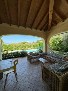 un patio con divani, tavolo e piscina di Villa Oliva a Manerba del Garda