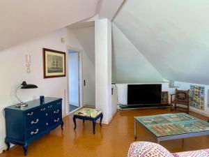 sala de estar con cómoda azul y TV en Palm Maresme - Suite with bathroom and living-room and terrasse with ocean views in a private villa en Vilassar de Dalt
