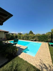 a swimming pool in a yard with two chairs at Villa Oliva in Manerba del Garda