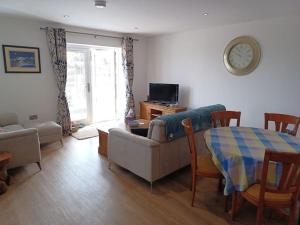 a living room with a couch and a clock on the wall at Admiral's View - Apartment 1 in Scarborough