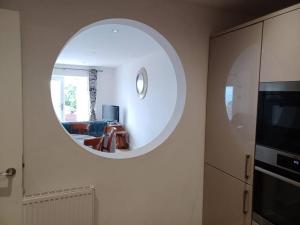 a circular mirror on a wall in a living room at Admiral's View - Apartment 1 in Scarborough +15 photos