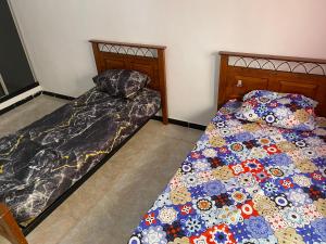 dos camas sentadas una al lado de la otra en un dormitorio en Akid, en Orán
