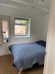 a bedroom with a bed and a window at Garden Annexe in Kinsham