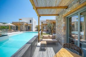 a swimming pool with a patio and a house at Azzure Luxury Suites in Potos
