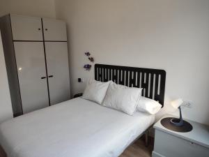a bedroom with a white bed with a black headboard at Voga Voga in Corcubión