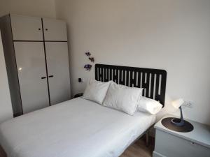 1 dormitorio con cama blanca y cabecero negro en Voga Voga, en Corcubión