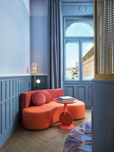 a living room with an orange couch and a table at W Budapest in Budapest