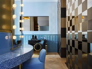 a bar with a blue chair and a mirror at W Budapest in Budapest