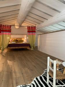 a bedroom with a bed with curtains and a wooden floor at La villa Paloma in Sylvéréal