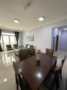 uma sala de estar com uma mesa de madeira e cadeiras em Fully Furnished 2bedroom apartment, Salalah, Oman em Salalah