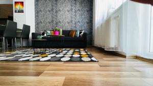 a living room with a black couch and a rug at Happy Living Apartment w Balcony in Budapest