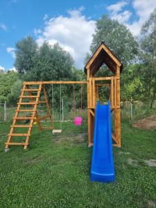a wooden play set with a slide and a ladder at La căbănute in Sibiu
