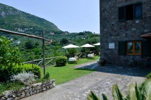 een huis met een tuin met stoelen en parasols bij Villevieille in Piano di Sorrento