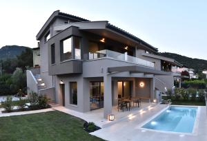 a house with a swimming pool in front of it at Welcome Inn in Paleo Tsifliki
