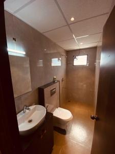 a bathroom with a white toilet and a sink at LK GRAND HOME in Tirupati