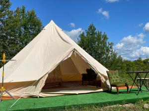 a white tent with a table and a chair at Luxury glamping at Kipeni 