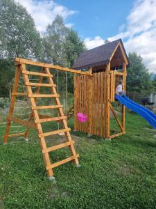 a child on a slide in a play house at La căbănute in Sibiu