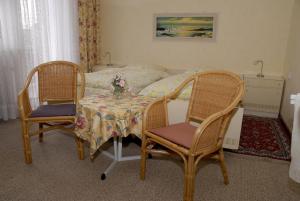 1 dormitorio con mesa, 2 sillas y 1 cama en Pension Familie Schwarz GbR, en Alhausen