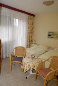 1 dormitorio con 1 cama, 2 sillas y mesa en Pension Familie Schwarz GbR en Alhausen