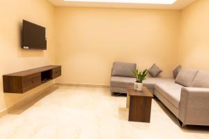 uma sala de estar com um sofá e uma televisão em LK GRAND HOME em Tirupati