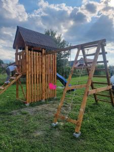 ein Holzspielgerät mit Rutsche und Spielplatz in der Unterkunft La căbănute in Sibiu