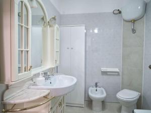 a white bathroom with a sink and a toilet at Casa vacanze BellaVista in Iglesias