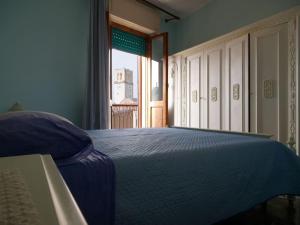a blue bedroom with a bed and a window at Casa vacanze BellaVista in Iglesias