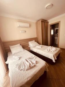 two beds in a hotel room with white sheets at Marina Apart Hotel in Marmaris