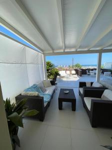 里米尼的住宿－Terrazza sul mare，阳台的天井配有沙发和桌子。