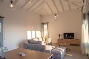 a living room with a couch and a table at Sunset Luxury Villa in Akritokhórion