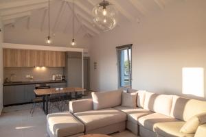 a living room with two couches and a kitchen at Sunset Luxury Villa in Akritokhórion