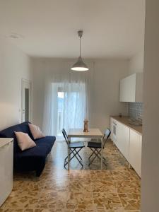 een woonkamer met een blauwe bank en een tafel bij Casa Luce in Brindisi di Montagna