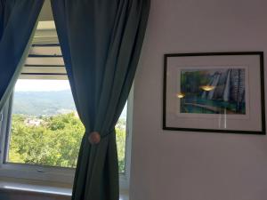 um quarto com uma janela com cortinas azuis e uma fotografia em Katarica em Korenica
