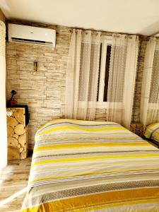 um quarto com uma cama e uma parede de tijolos em Charmante maisonnette proche plage em Fréjus