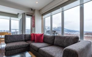 a living room with a couch with red pillows at Snow Crystal in Kutchan +34 photos